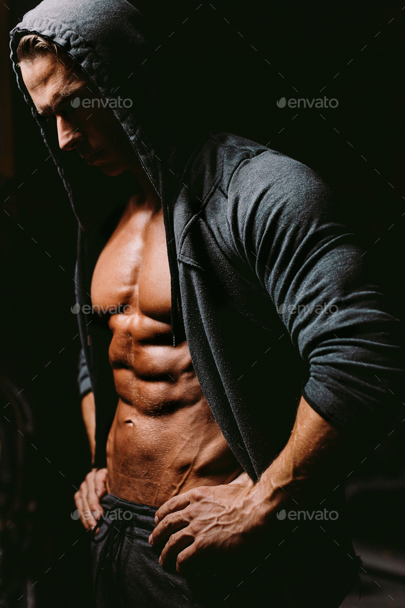 Brutal bodybuilder athlete torso in hoodie with abs and chest